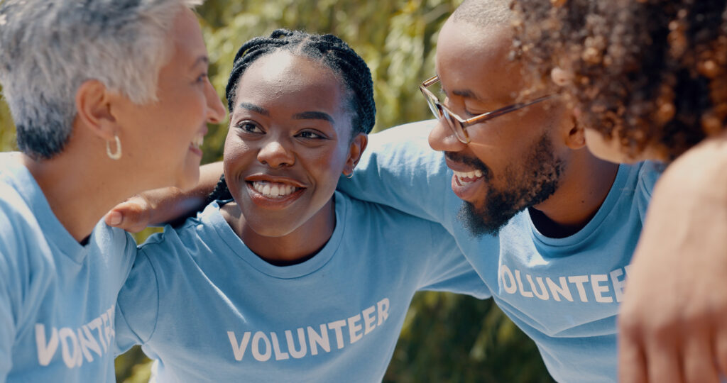 Smiling volunteers in blue shirts huddling