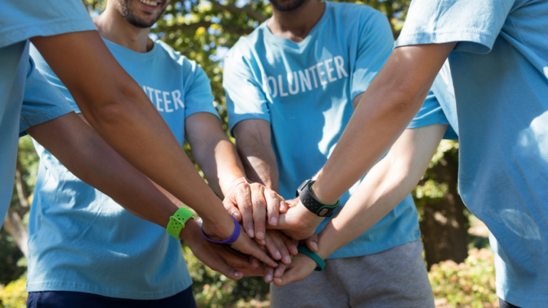 Volunteers stacking hands in team huddle